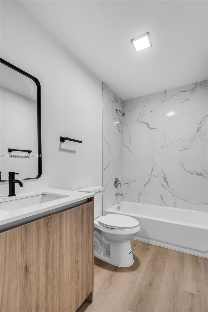 3728 Northwest 19th Avenue, Unit 101 Miami, FL 33142 - Photo 11 of 11 a bathroom with a sink a toilet and a mirror