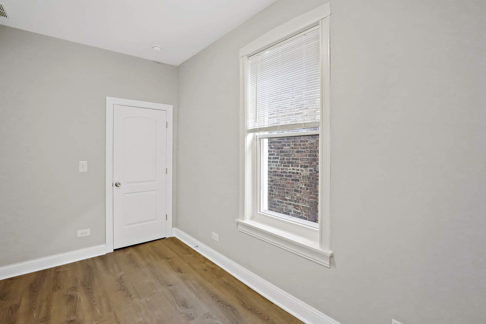 2626 North Ridgeway Avenue, Unit 1 Chicago, IL 60647 - Photo 12 of 16 an empty room with wooden floor and windows