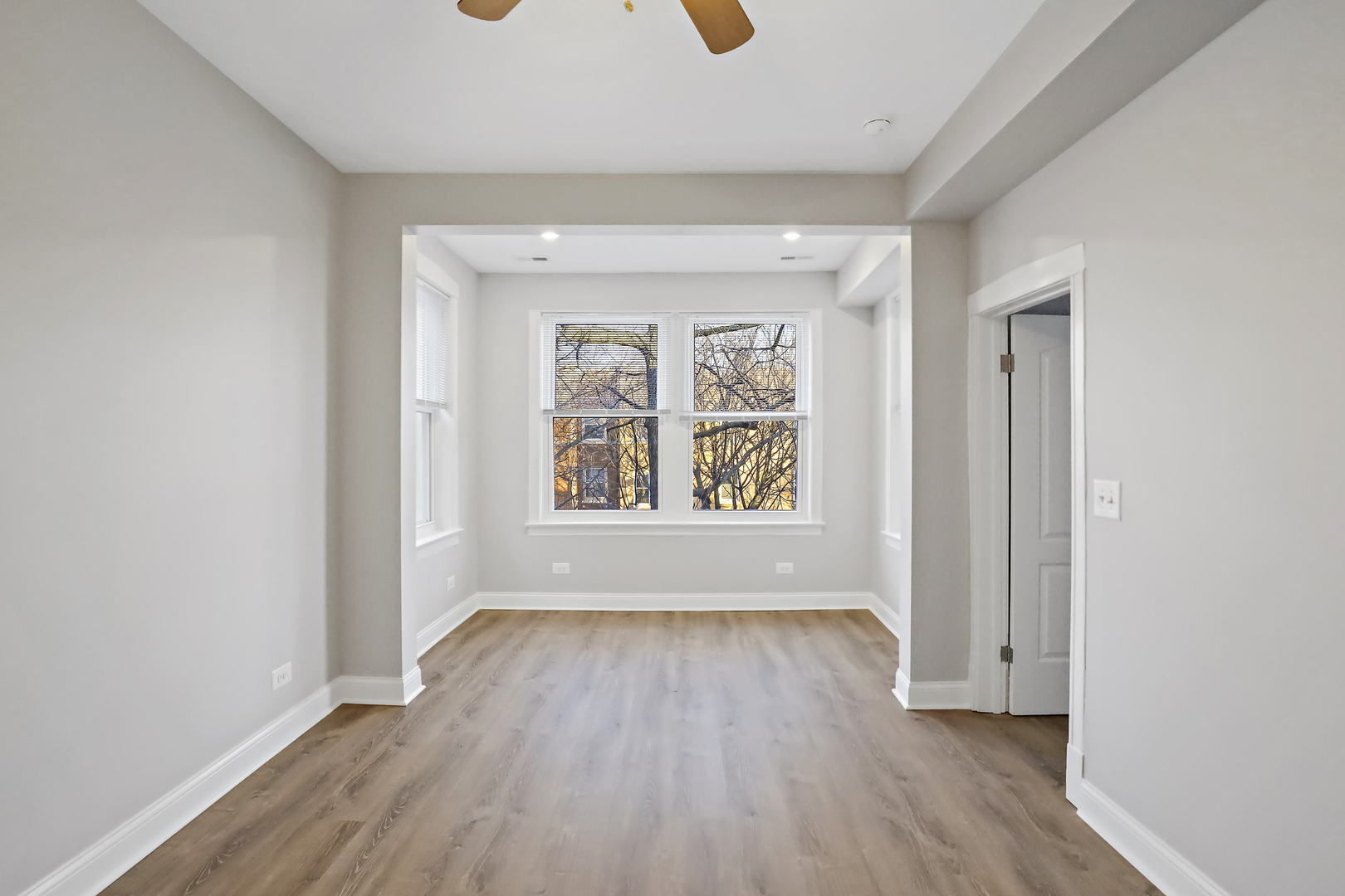2626 North Ridgeway Avenue, Unit 1 Chicago, IL 60647 - Photo 5 of 16 an empty room with wooden floor and windows