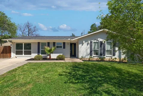 a front view of a house with a yard and sitting area