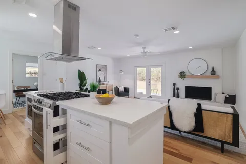 a kitchen with stainless steel appliances granite countertop a stove a sink and a refrigerator