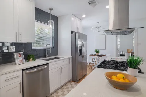 a kitchen with stainless steel appliances a sink a counter space and cabinets