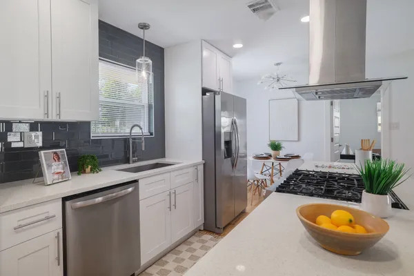 a kitchen with stainless steel appliances a sink a counter space and cabinets