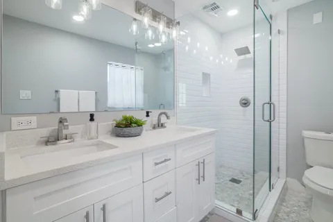 a bathroom with a sink a toilet and shower