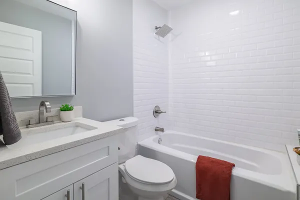 a bathroom with a granite countertop sink a toilet and bathtub
