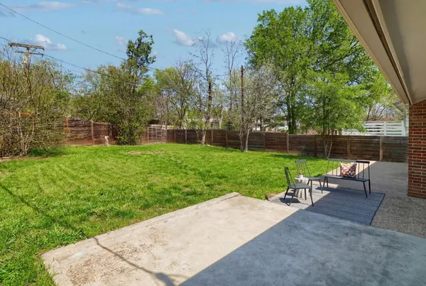 a view of a backyard with a garden and entertaining space