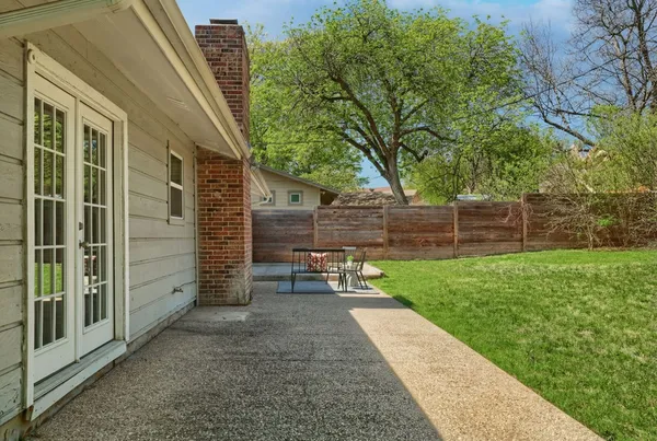 a view of a backyard with wooden fence and a bench
