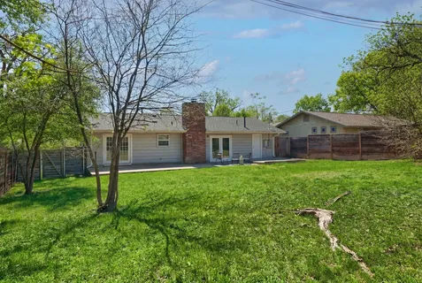 a view of a house with backyard and a tree