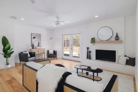 a living room with furniture a fireplace and a large window