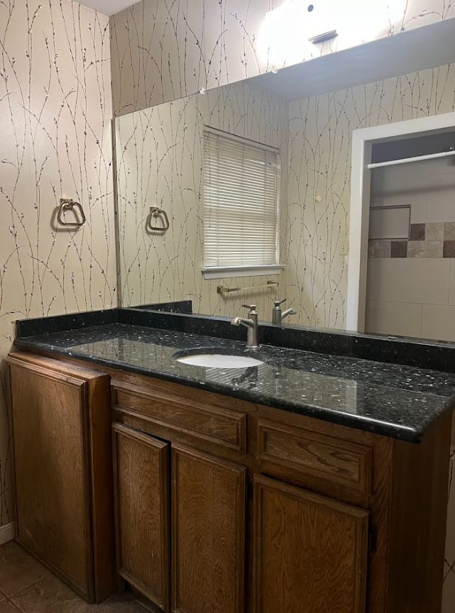 2813 1/2 Rio Grande Street, Unit 5 Austin, TX 78701 - Photo 16 of 21 a bathroom with a granite countertop sink and a mirror