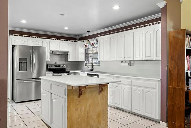 a kitchen with a sink a refrigerator and cabinets