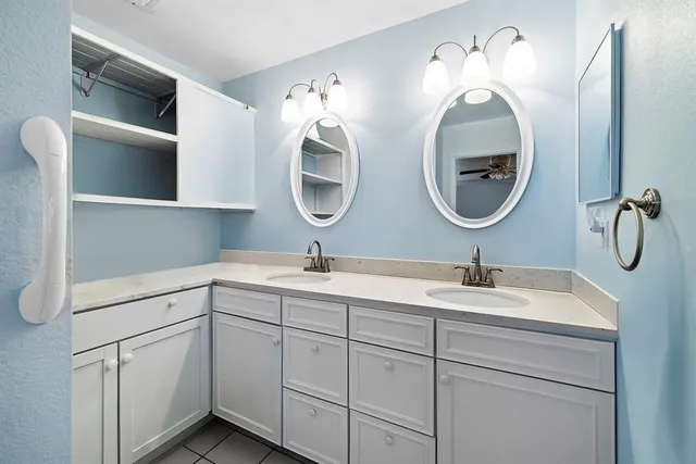 a bathroom with a double vanity sink and a mirror