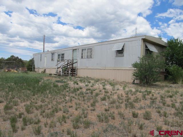 25333 Cedar Mesa Road Cedaredge, CO 81413 - Photo 2 of 19 a backyard of a house with table and chairs