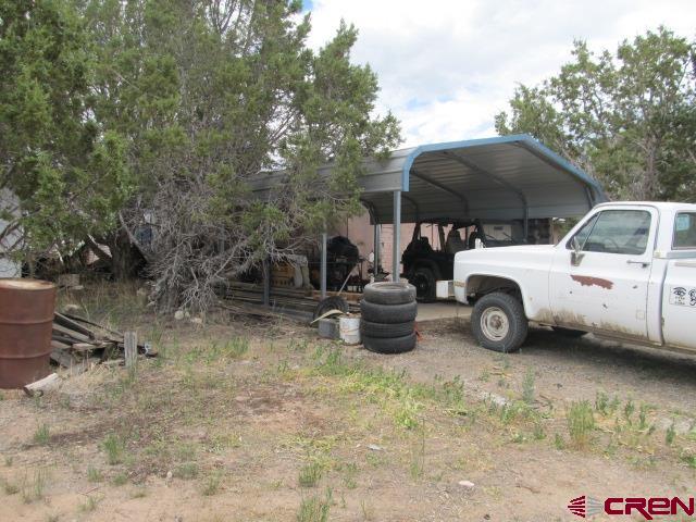 25333 Cedar Mesa Road Cedaredge, CO 81413 - Photo 8 of 19 a view of a backyard with table and chairs under an umbrella