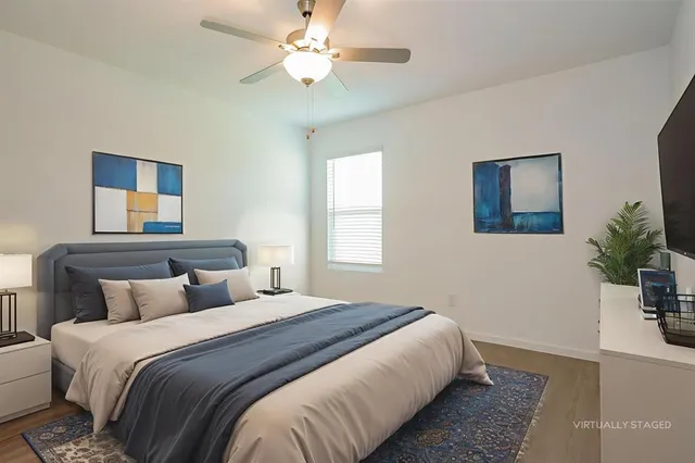 a bedroom with a large bed and a potted plant