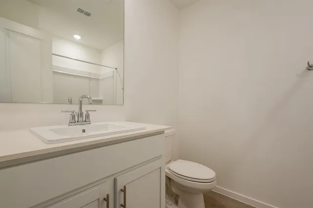 a bathroom with a sink a toilet and a mirror