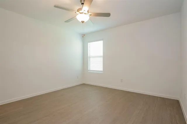 an empty room with a window and a fan
