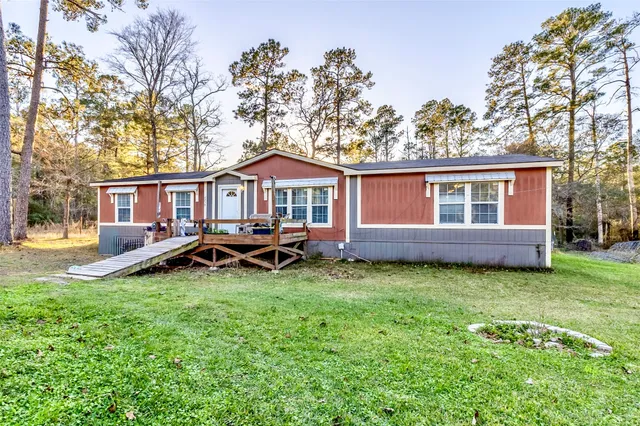 a view of a house with a yard and deck