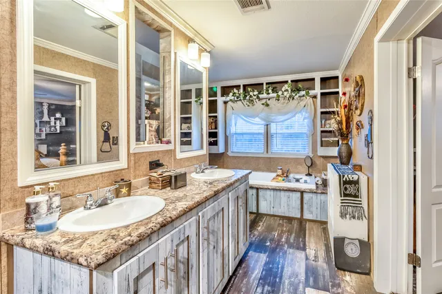 a bathroom with a granite countertop sink a mirror a window and a shower