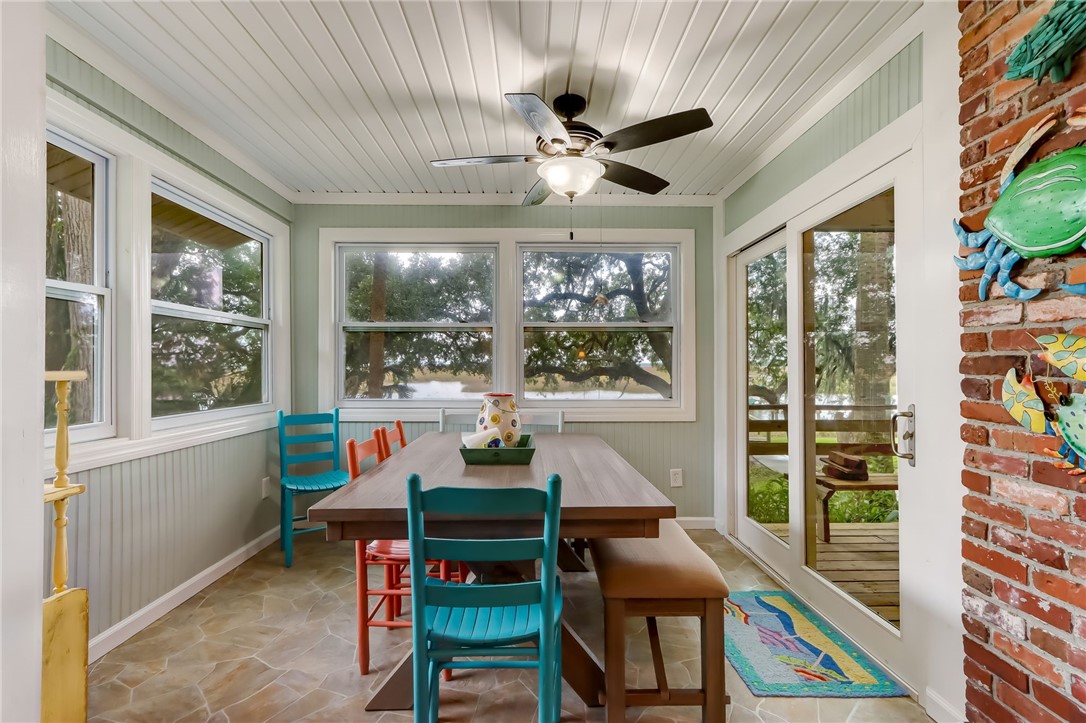 97020 Pirates Point Road Yulee, FL 32097 - Photo 8 of 35 a dining room with furniture a flat screen tv and a floor to ceiling window