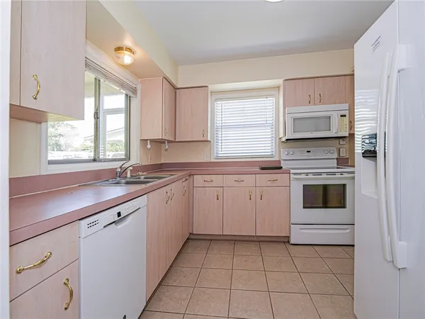 a kitchen with cabinets appliances and a window