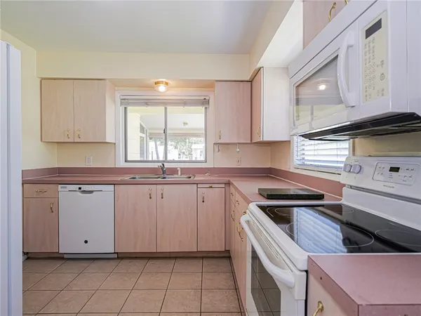 a kitchen with granite countertop white cabinets and white appliances