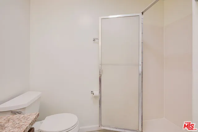 a white toilet sitting next to a shower