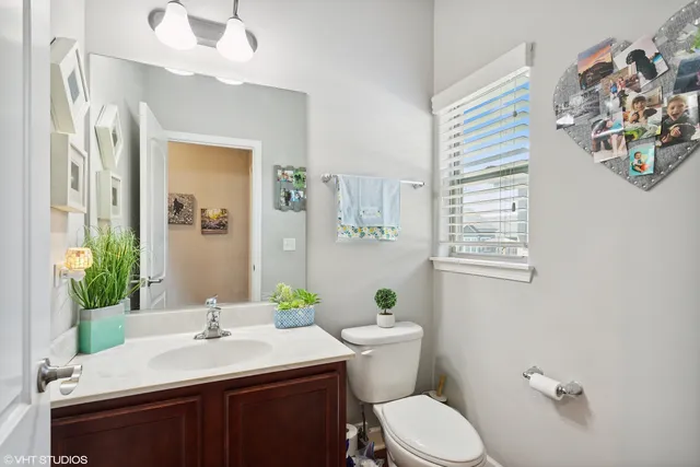 a bathroom with a sink vanity mirror and toilet