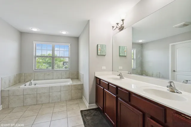 a spacious bathroom with a bathtub sink and mirror