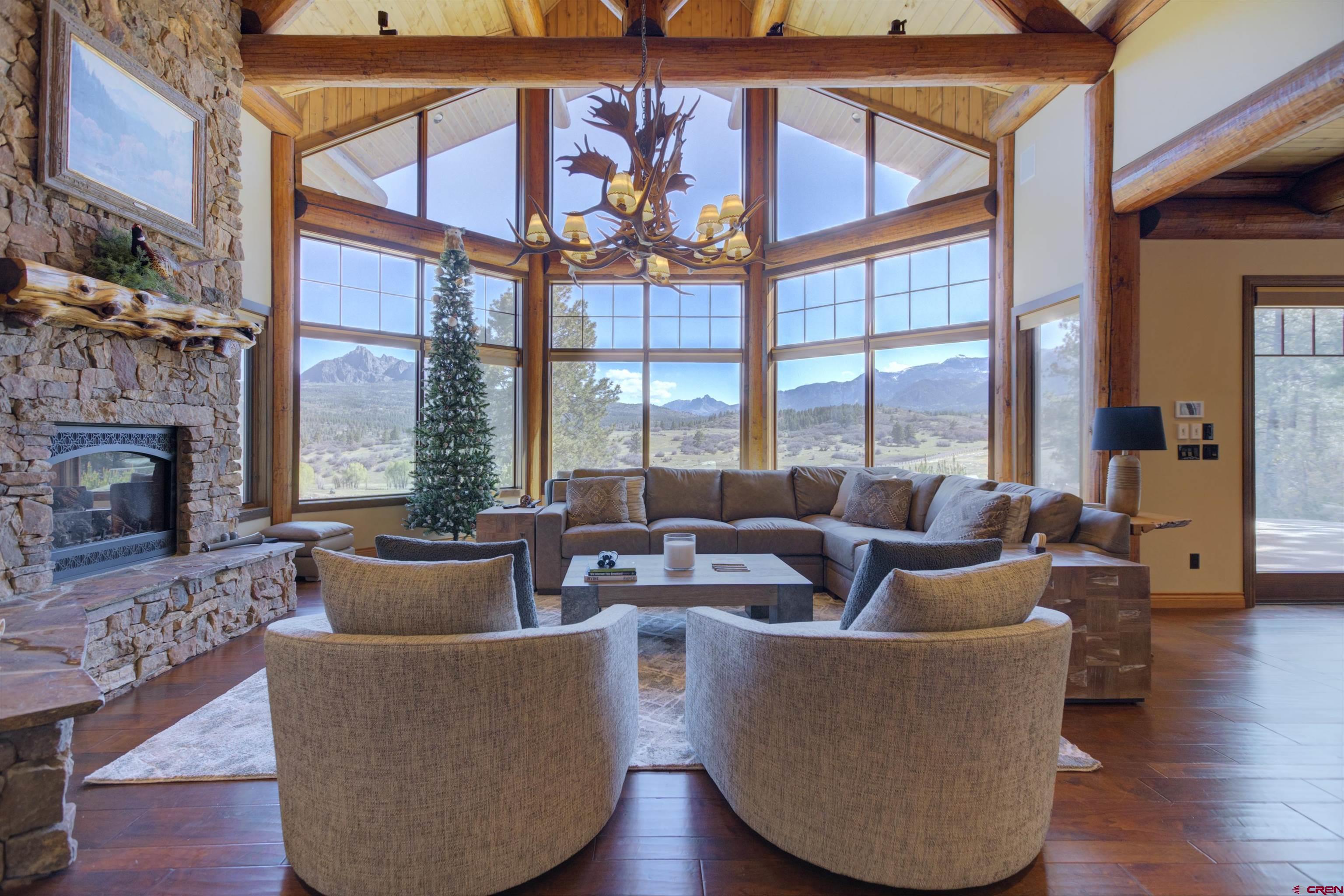 702 Jenni Lane, Unit SADDLEHORN RANCH Chromo, CO 81128 - Photo 14 of 45 a living room with fireplace furniture large windows and wooden floor