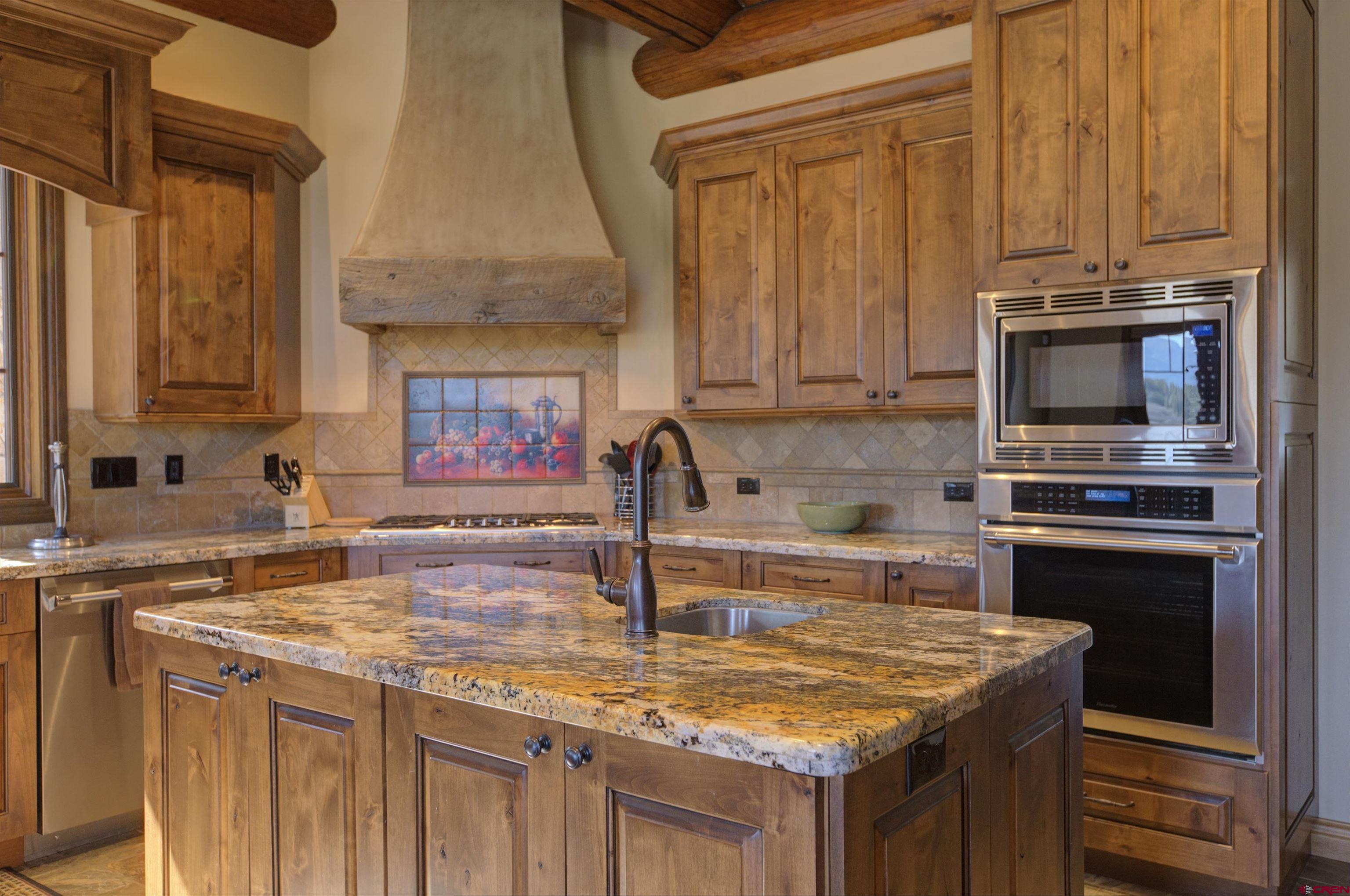 702 Jenni Lane, Unit SADDLEHORN RANCH Chromo, CO 81128 - Photo 20 of 45 a kitchen with kitchen island granite countertop a sink stove and microwave