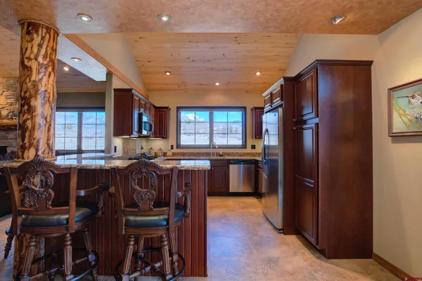 a kitchen with a refrigerator and a dining table