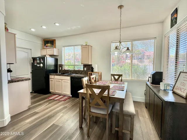 a kitchen with a table chairs refrigerator and microwave