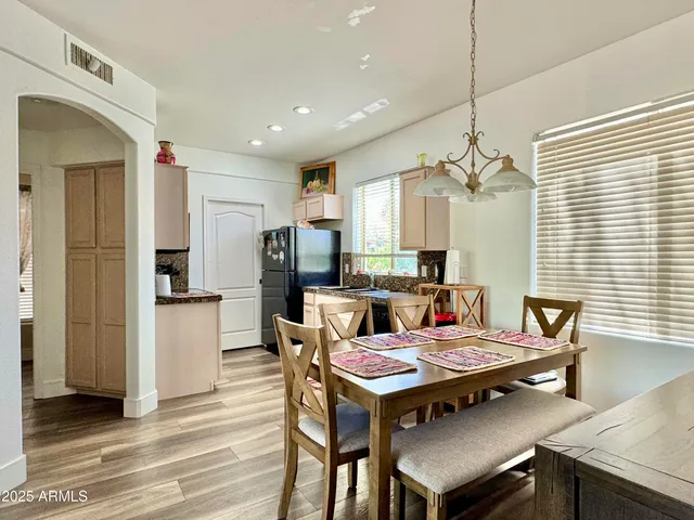 a view of a dining room with furniture a chandelier and wooden floor