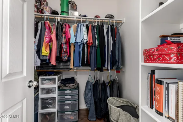 a view of walk in closet with clothes and shoes