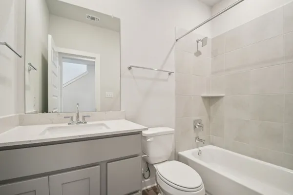 a bathroom with a sink toilet vanity and shower