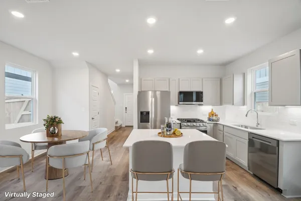 a kitchen with a dining table chairs and sink