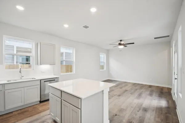 a kitchen with a sink cabinets and wooden floor