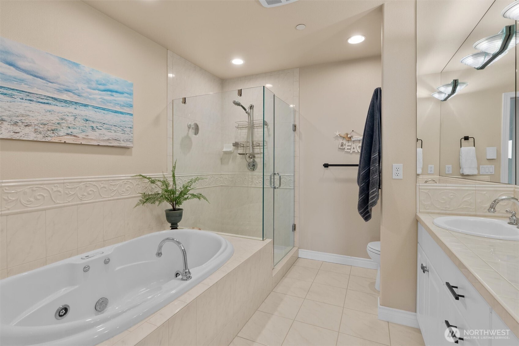 1005 Harbor Avenue Southwest, Unit 400 Seattle, WA 98116 - Photo 15 of 39 a bathroom with a granite countertop sink a mirror a bathtub and shower