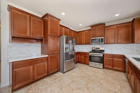a metallic refrigerator freezer sitting inside of a kitchen