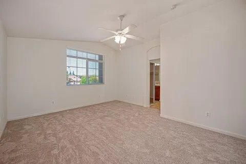 an empty room with fan and windows