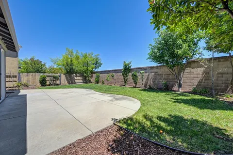 a view of a backyard with brick wall and potted plants