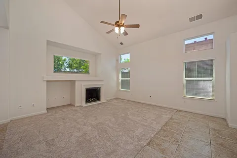an empty room with windows and fireplace