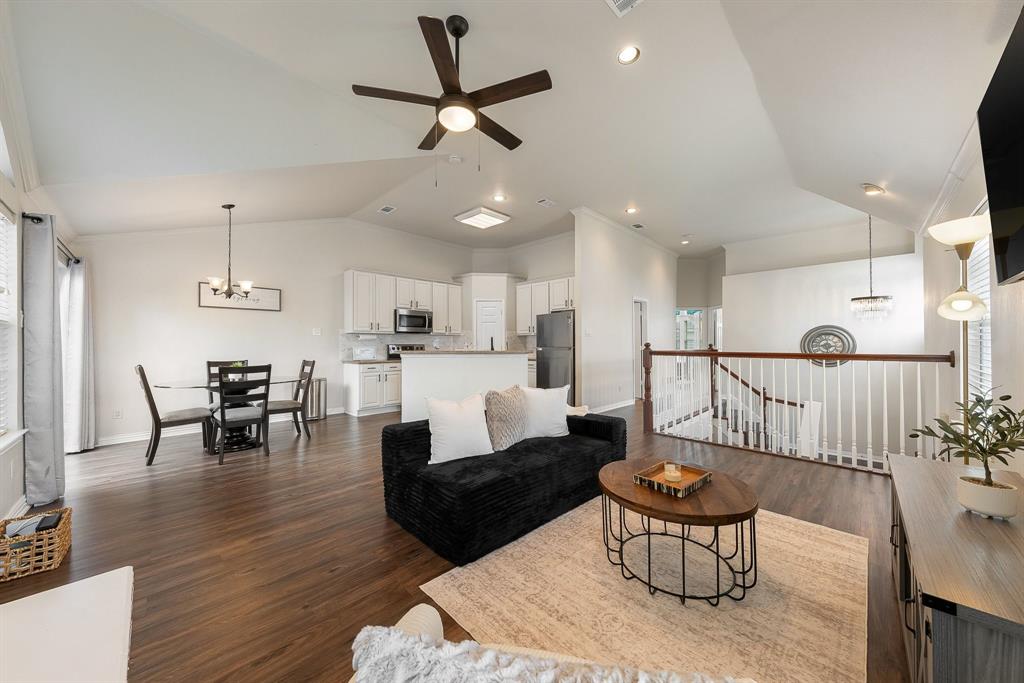 18240 Midway Road, Unit 1301 Dallas, TX 75287 - Photo 2 of 25 Open-concept living area featuring wood-finish flooring, vaulted ceilings, and a decorative ceiling fan