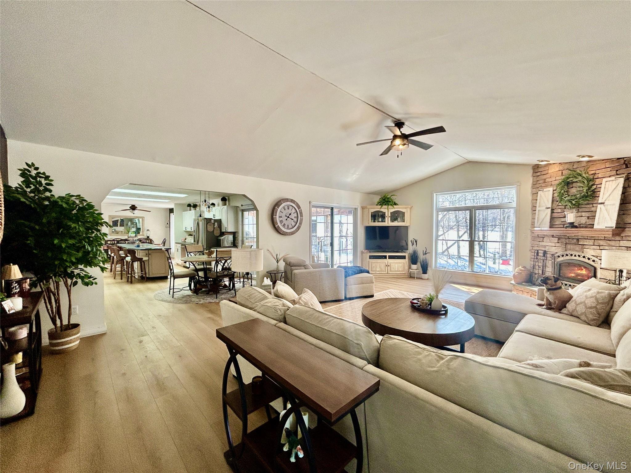 290 Gulf Road Roscoe, NY 12776 - Photo 13 of 30 Living room featuring ceiling fan, arched walkways, hardwood / wood-style floors, and a stone fireplace