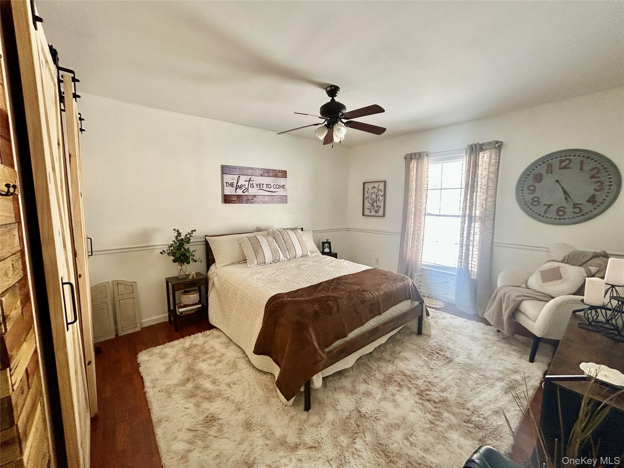 290 Gulf Road Roscoe, NY 12776 - Photo 18 of 26 Bedroom featuring a barn door, dark wood finished floors, and a ceiling fan
