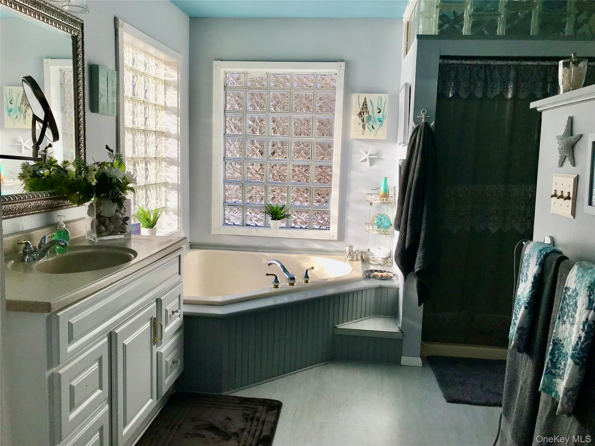 290 Gulf Road Roscoe, NY 12776 - Photo 23 of 26 Full bath with a garden tub, vanity, and light wood-type flooring