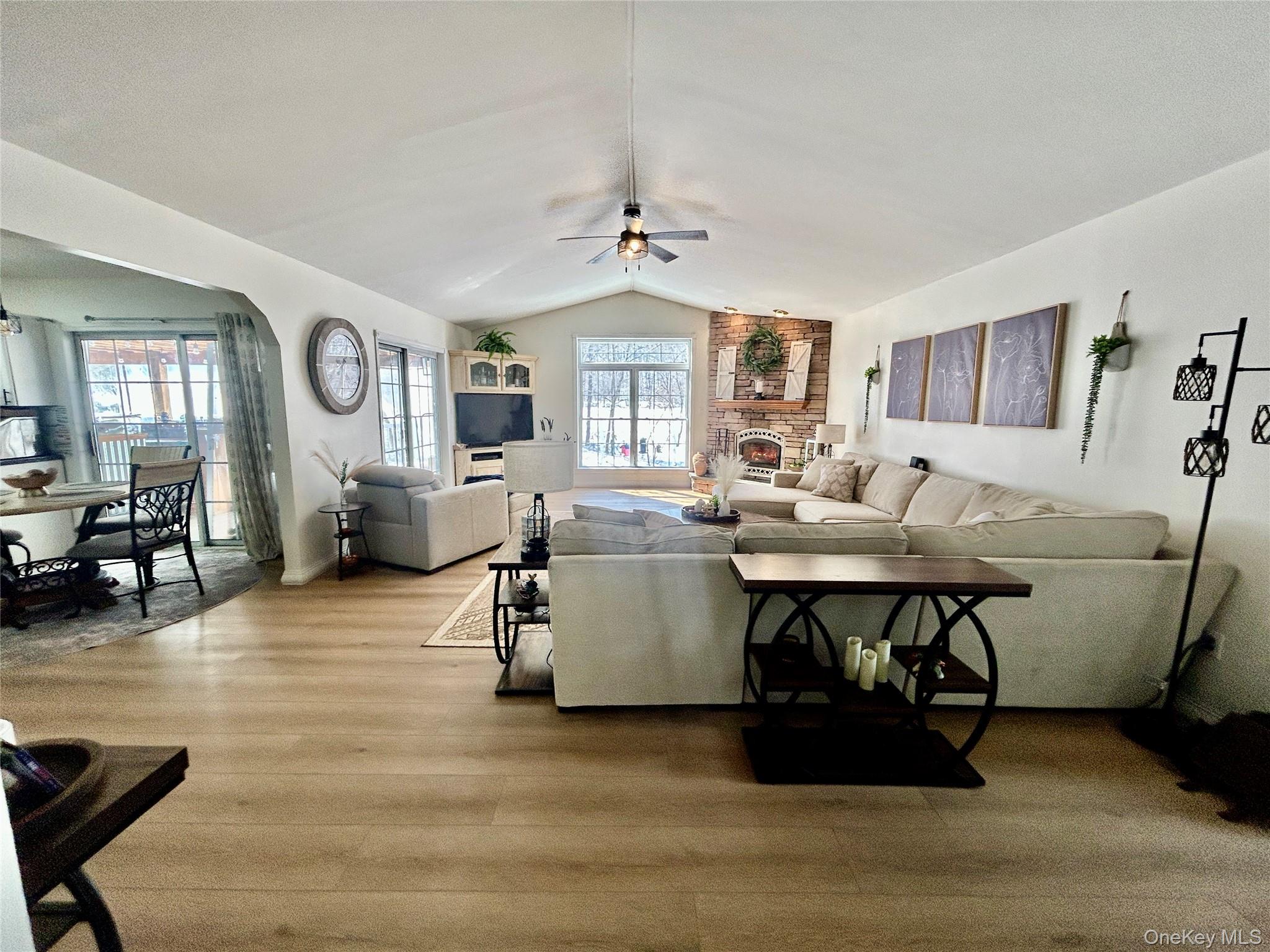 290 Gulf Road Roscoe, NY 12776 - Photo 9 of 26 Living room with wood finished floors, ceiling fan, arched walkways, and a fireplace
