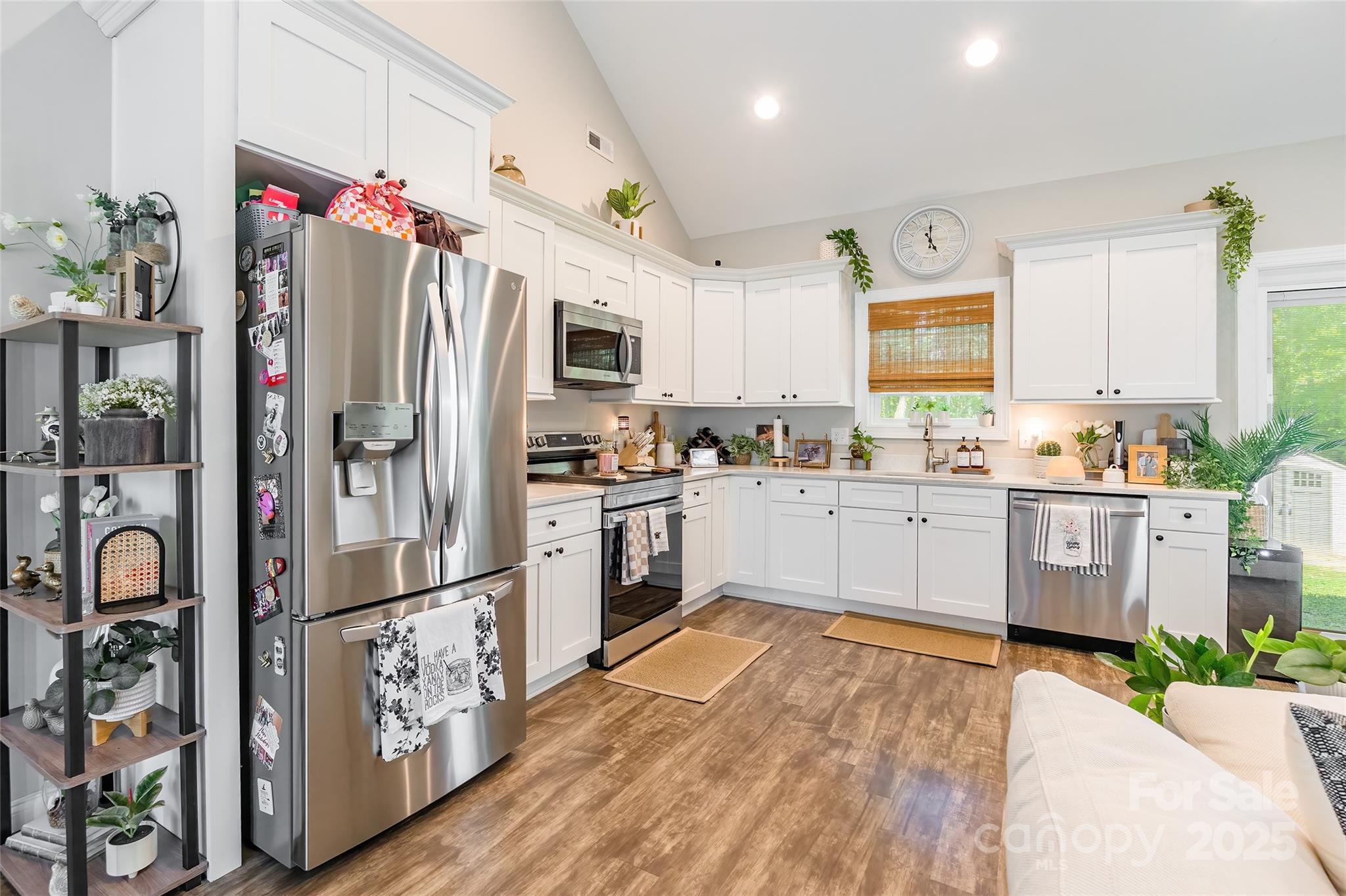 137 Ole Eastpointe Drive York, SC 29745 - Photo 9 of 28 a kitchen with granite countertop a refrigerator a sink dishwasher and white cabinets with wooden floor