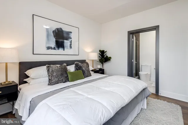 a bedroom with a large bed and a painting on the wall